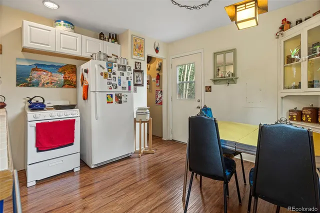 a view of a dining room with furniture a rug and wooden floor