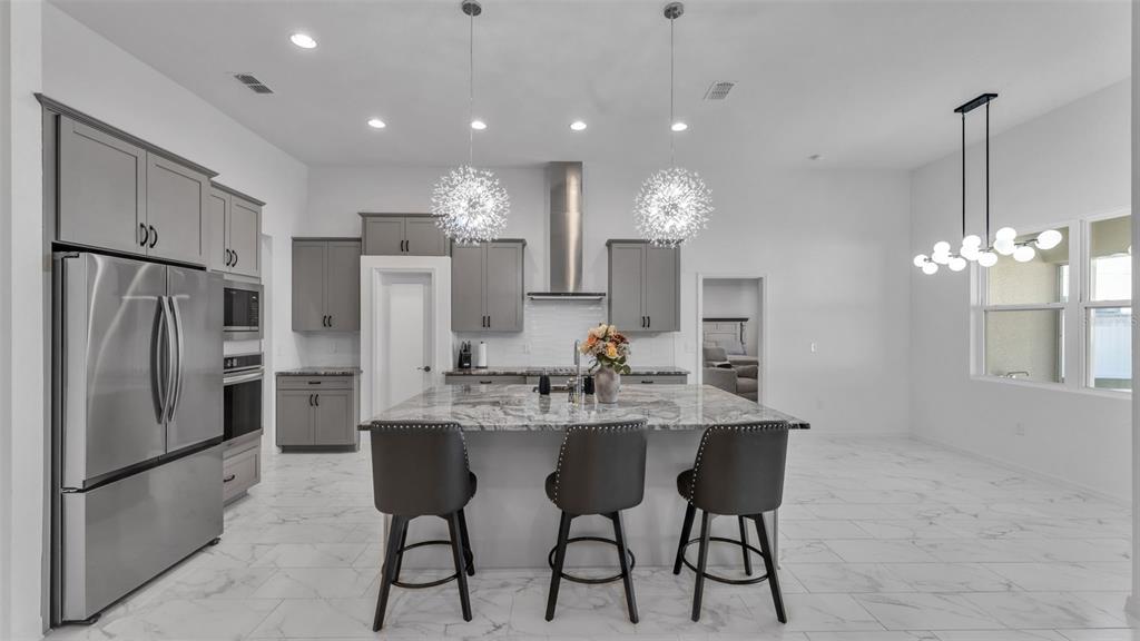 1029 Bergamot Drive Bartow, FL 33830 - Photo 20 of 62 a kitchen with stainless steel appliances kitchen island granite countertop a dining table chairs refrigerator and cabinets