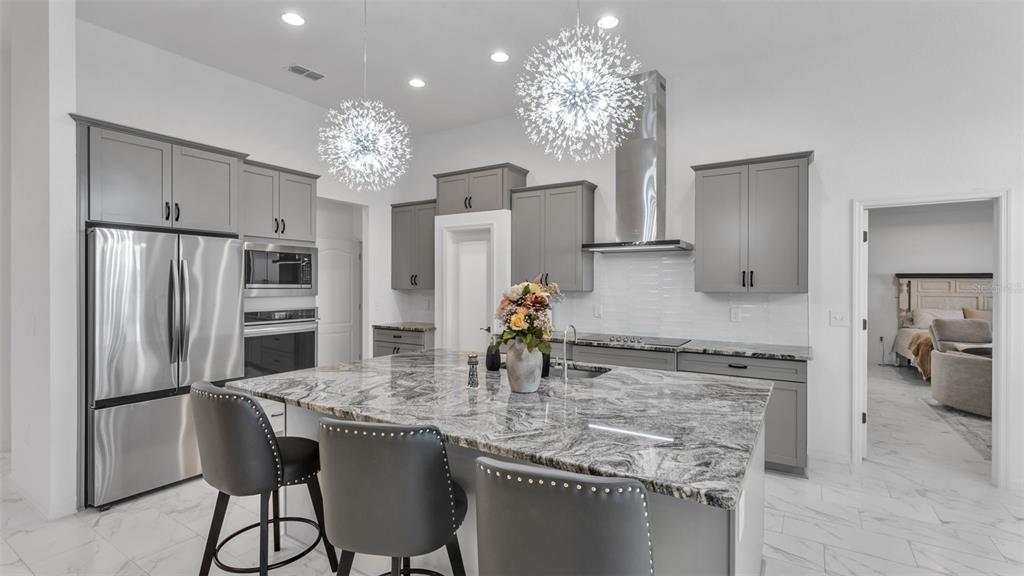 1029 Bergamot Drive Bartow, FL 33830 - Photo 21 of 62 a kitchen with stainless steel appliances granite countertop a refrigerator a stove a oven a dining table and chairs with wooden floor