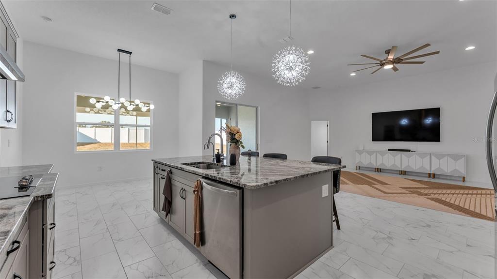 1029 Bergamot Drive Bartow, FL 33830 - Photo 25 of 62 a living room with granite countertop furniture a flat screen tv and a chandelier