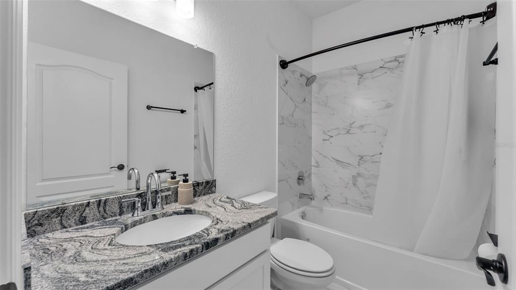 1029 Bergamot Drive Bartow, FL 33830 - Photo 46 of 62 a bathroom with a granite countertop sink toilet mirror and shower