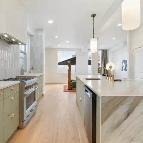 a kitchen with sink stove and refrigerator