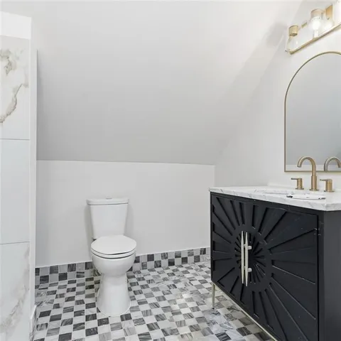 a bathroom with a sink a toilet and a mirror