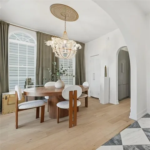 a dining room with furniture a chandelier and window