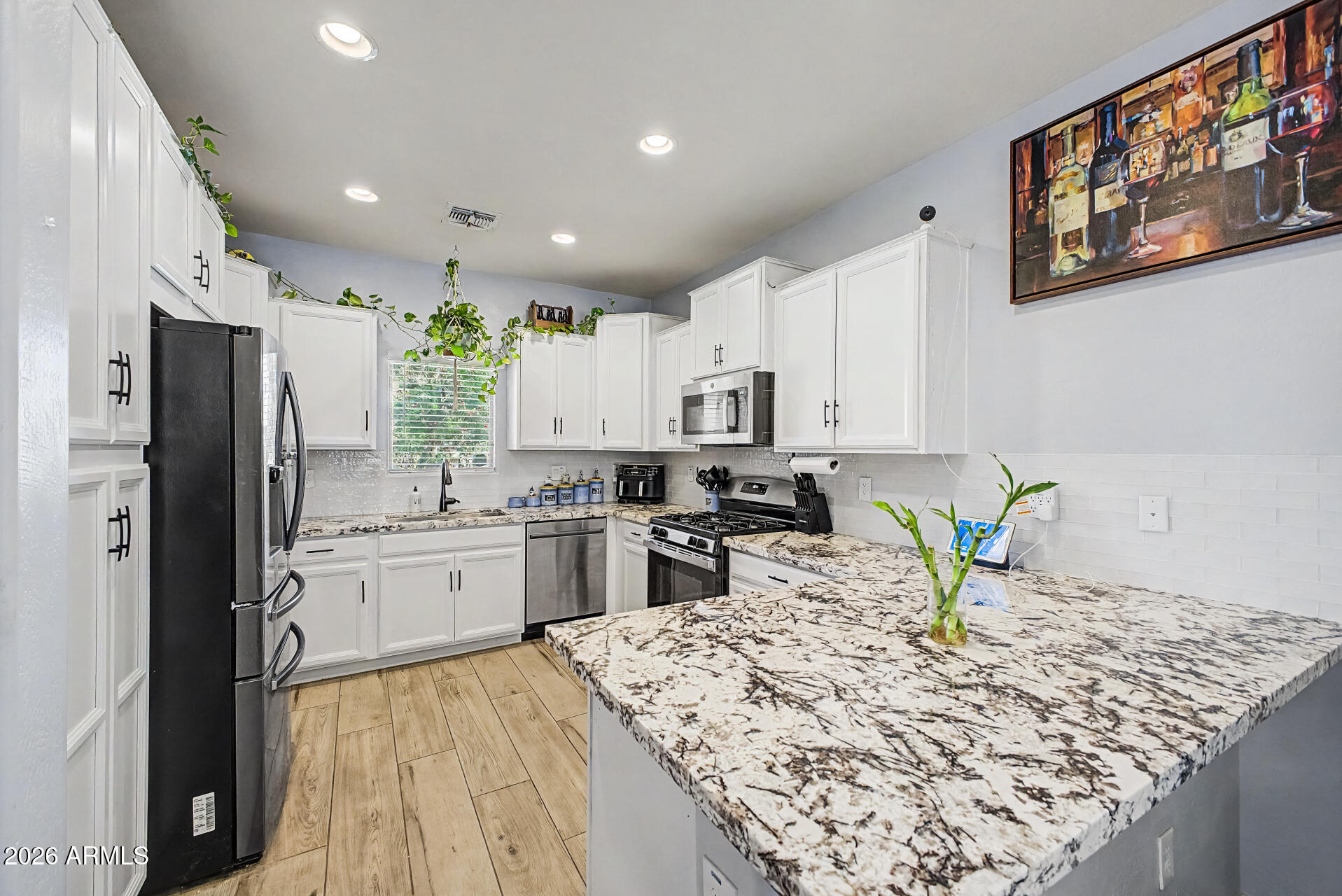 16719 West Rowel Road Surprise, AZ 85387 - Photo 5 of 28 a kitchen with stainless steel appliances granite countertop refrigerator sink and stove