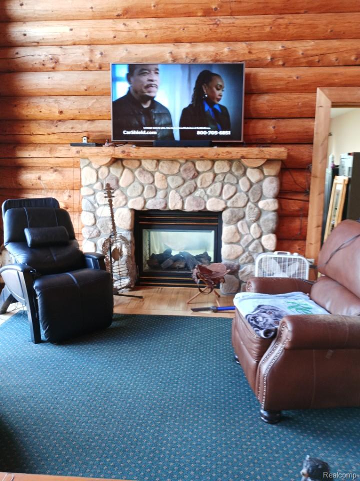 10374 Wilson Road Otisville, MI 48463 - Photo 50 of 99 Living room with a stone fireplace and log walls