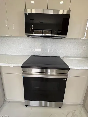 a stove top oven sitting inside of a kitchen