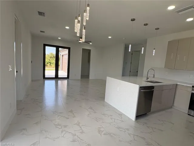 a view of kitchen with sink and refrigerator