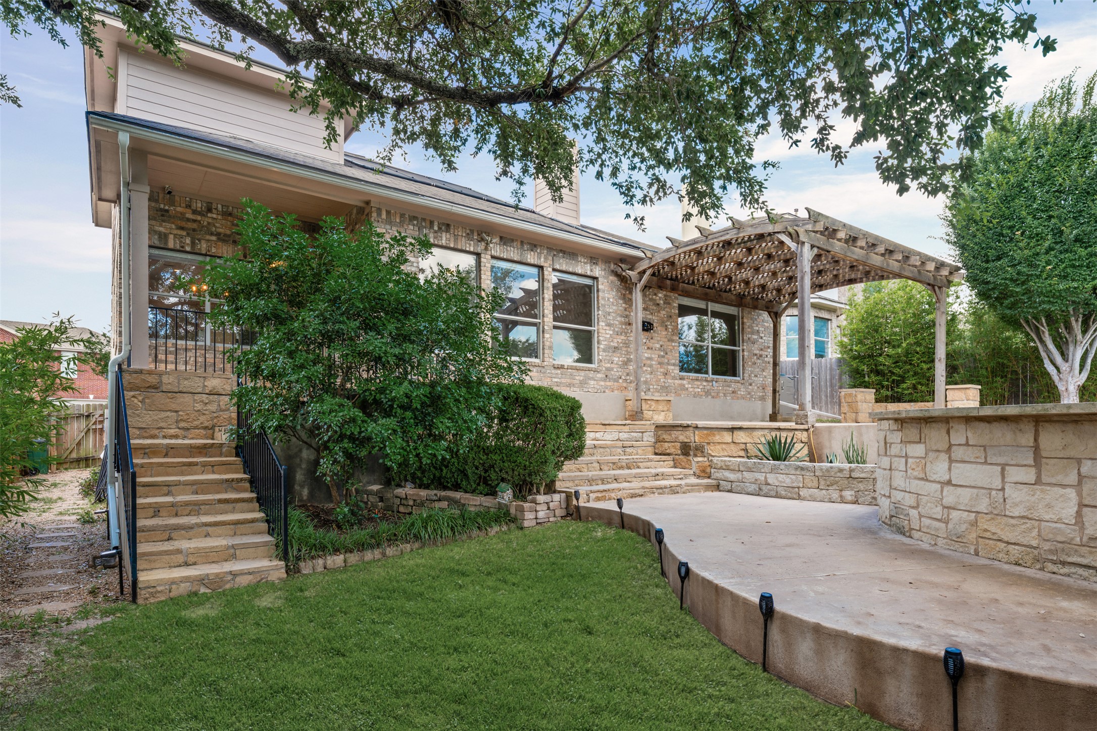 8820 Colberg Drive Austin, TX 78749 - Photo 30 of 35 A charming exterior with brick and stone accents features a pergola and tiered landscaping.
