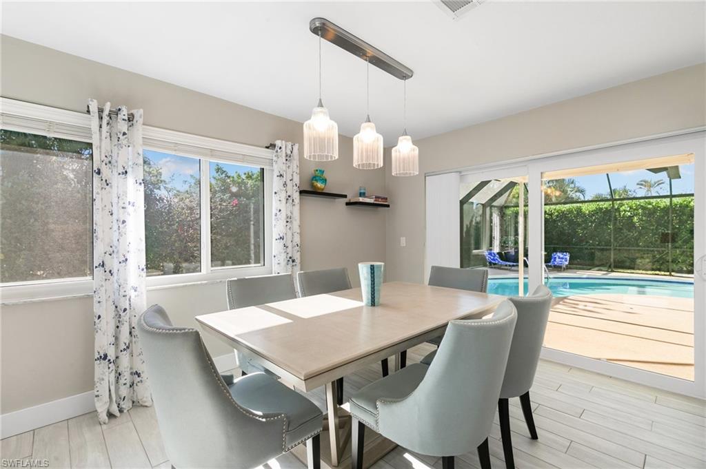 230 Pine Valley Circle Naples, FL 34113 - Photo 12 of 40 a view of a dining room with furniture window and wooden floor