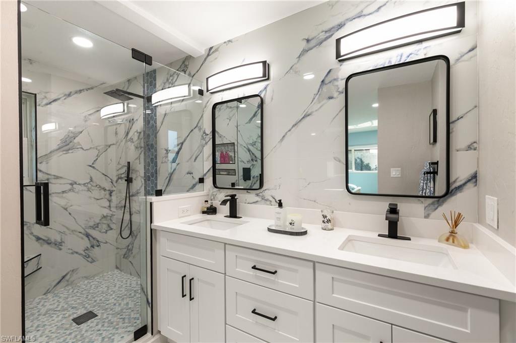230 Pine Valley Circle Naples, FL 34113 - Photo 20 of 40 a bathroom with a double vanity sink mirror and shower