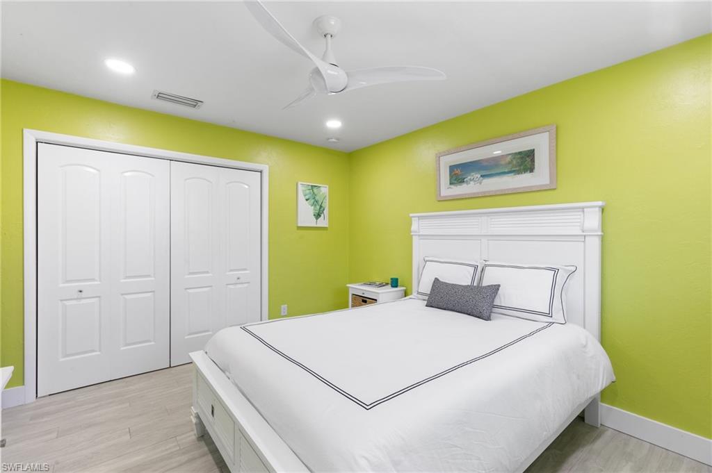 230 Pine Valley Circle Naples, FL 34113 - Photo 23 of 40 a bedroom with a bed and a wall painting