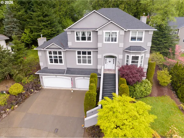 a front view of a house with a yard and trees