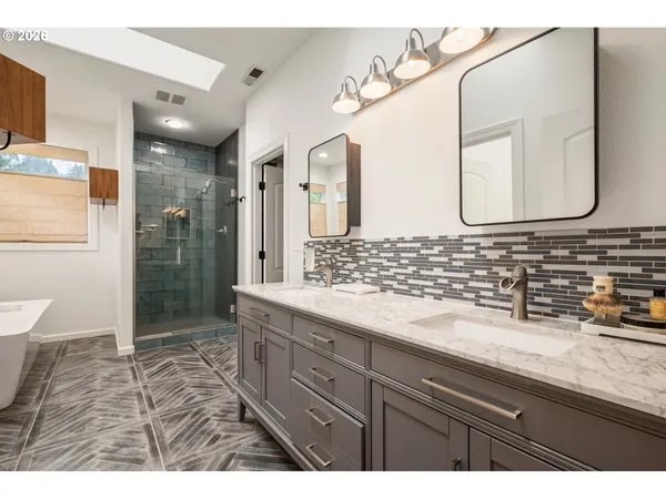 a bathroom with a granite countertop sink a mirror and a shower
