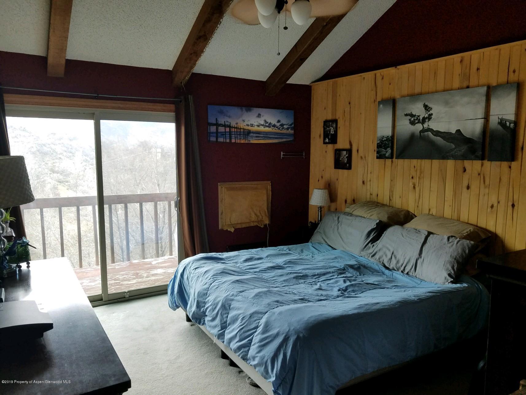 515 East 11th Street Rifle, CO 81650 - Photo 18 of 23 a bedroom with a large bed and a large window