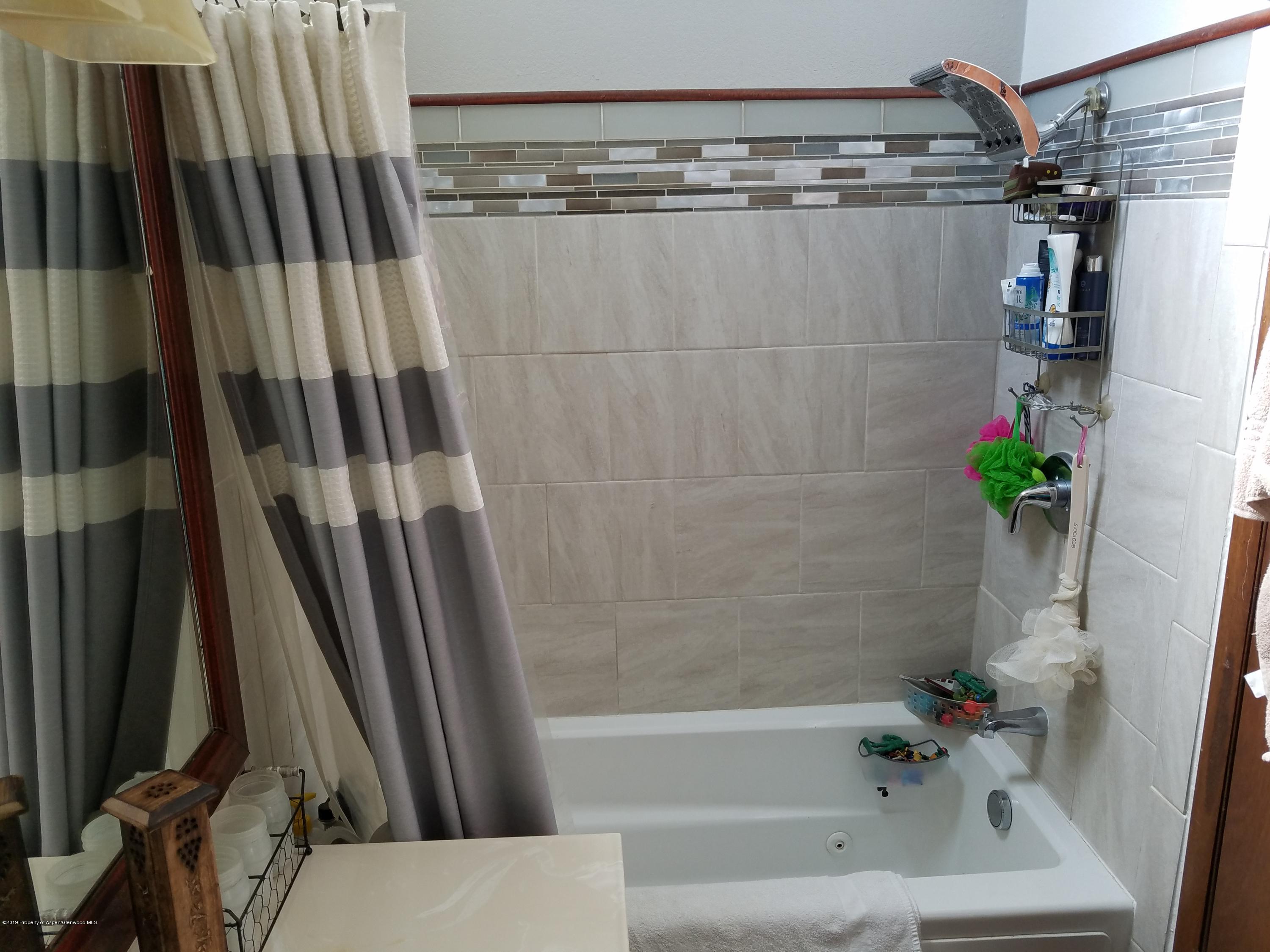 515 East 11th Street Rifle, CO 81650 - Photo 21 of 23 a bathroom with a shower and a tub