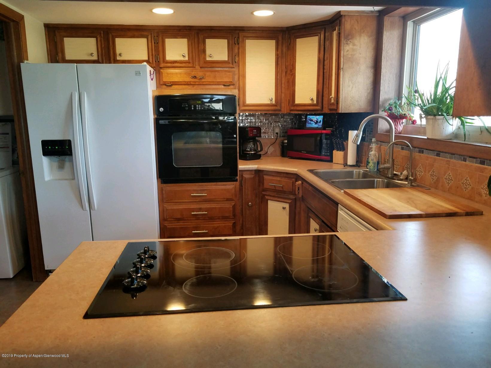 515 East 11th Street Rifle, CO 81650 - Photo 6 of 23 a kitchen with a sink and a refrigerator