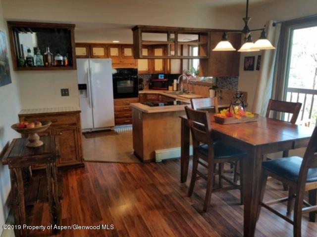 515 East 11th Street Rifle, CO 81650 - Photo 9 of 23 a kitchen with stainless steel appliances granite countertop a stove top oven a sink a dining table and chairs with wooden floor