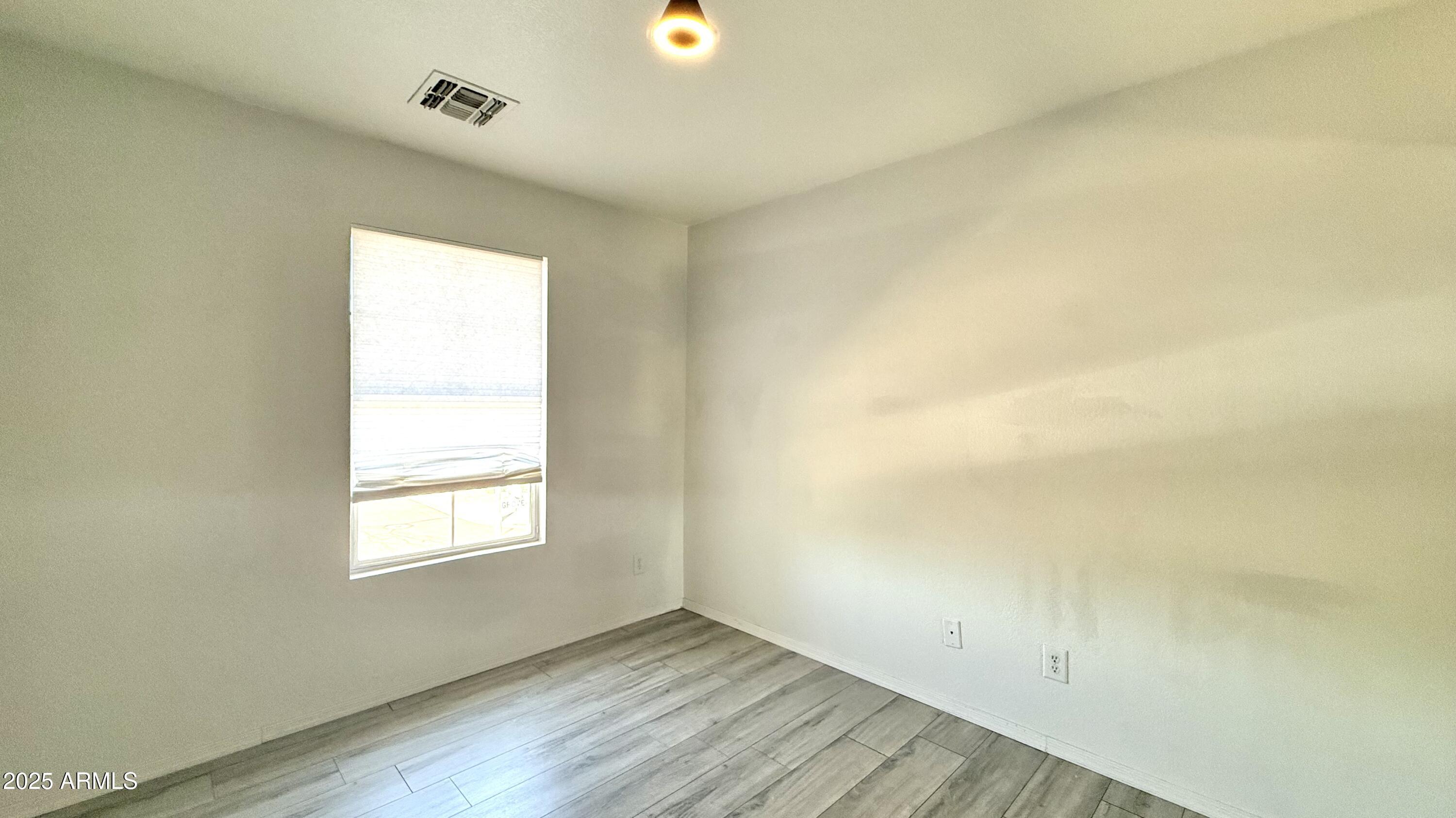 1103 East Grove Street Phoenix, AZ 85040 - Photo 15 of 21 an empty room with wooden floor and windows