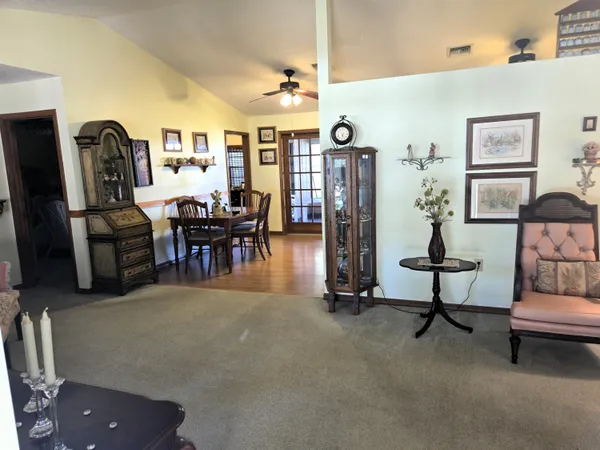 a living room with furniture a dining table and large windows