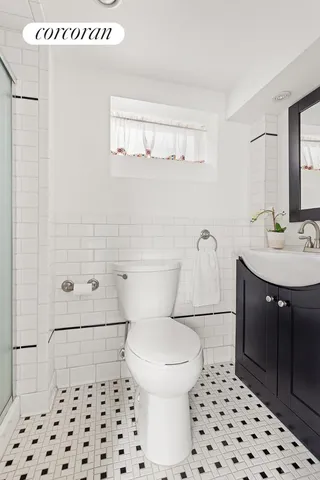 a bathroom with a sink a toilet a shower and a mirror