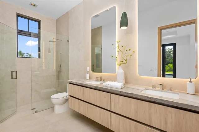 a bathroom with a granite countertop sink a toilet and shower