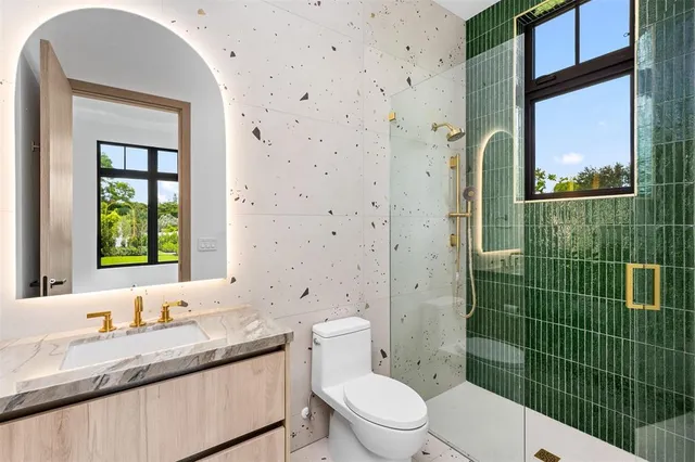 a bathroom with a granite countertop toilet sink and mirror