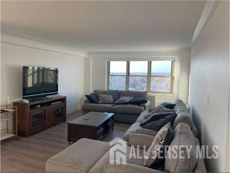 28 Riverside Avenue, Unit 11H Red Bank, NJ 07701 - Photo 2 of 5 a living room with furniture and a flat screen tv