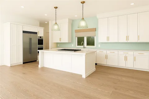 a kitchen with stainless steel appliances granite countertop a stove a sink and a refrigerator