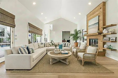 a living room with fireplace furniture and a rug