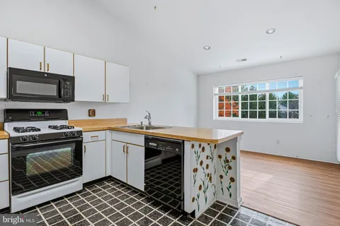 a kitchen with stainless steel appliances a stove a sink and a microwave