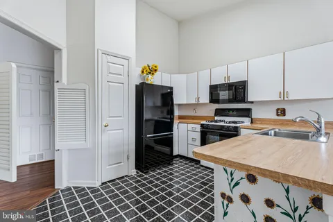 a kitchen with granite countertop a refrigerator and a stove top oven