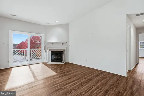 a view of a livingroom with wooden floor and a fireplace