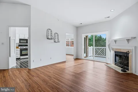 a view of a livingroom with wooden floor and a fireplace