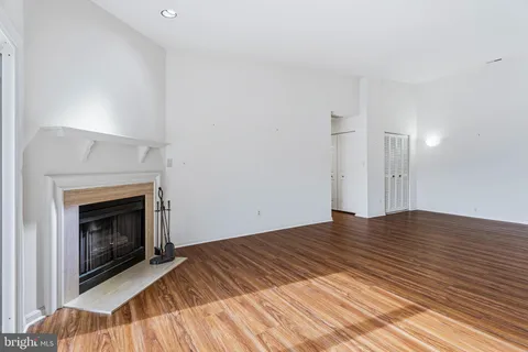 a view of empty room with wooden floor and fireplace