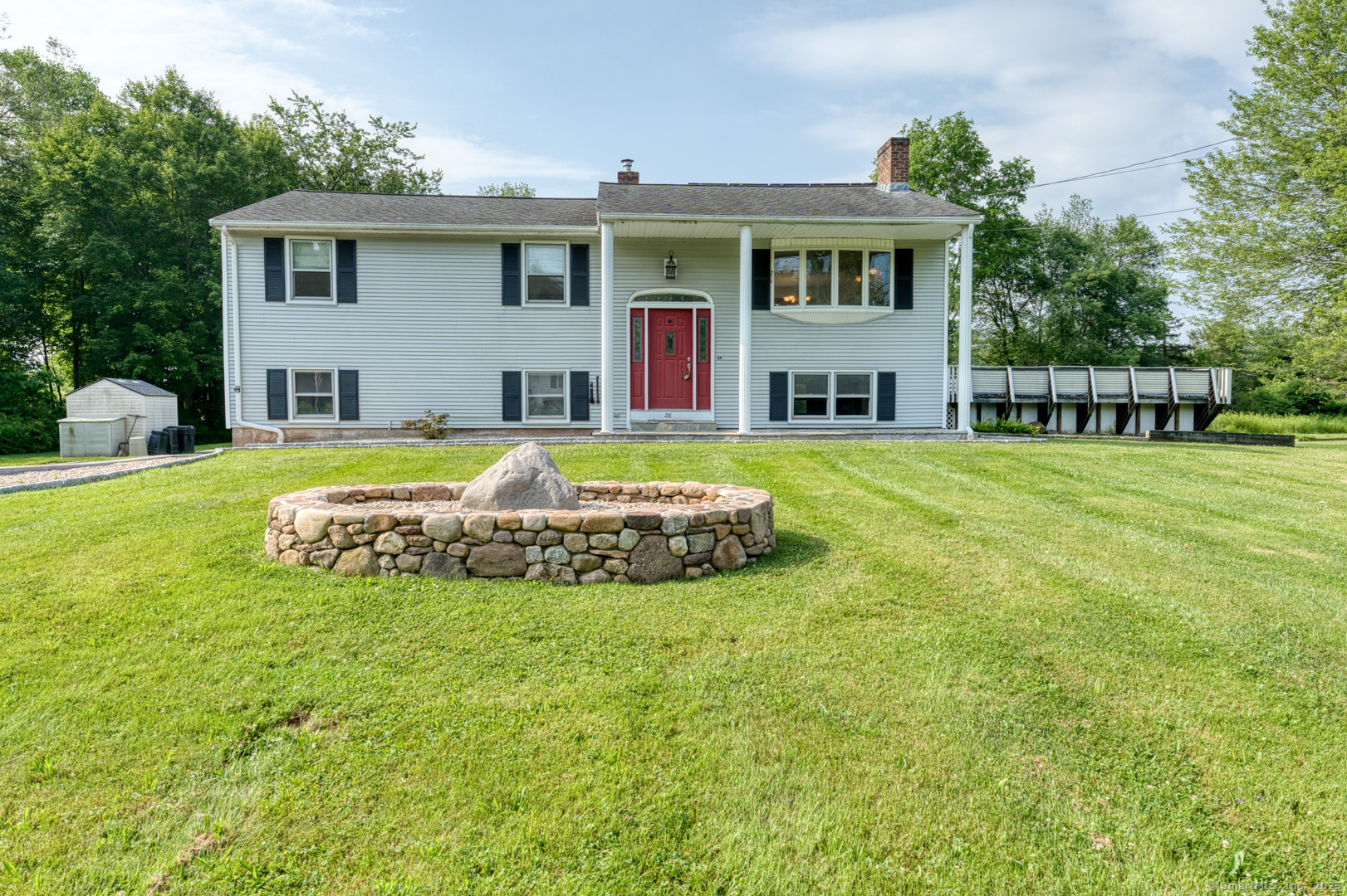 a view of a house with a big yard and large trees
