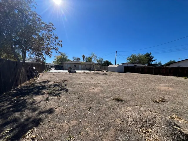a view of a yard with wooden fence