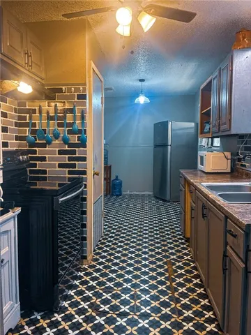 a kitchen with granite countertop a refrigerator and a stove