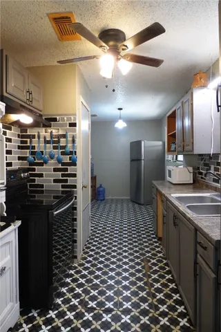 a kitchen with stainless steel appliances kitchen island granite countertop a refrigerator and a sink
