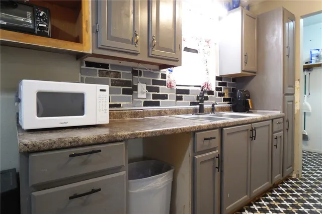 a kitchen with stainless steel appliances granite countertop a sink stove and microwave