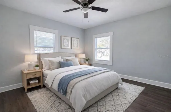 a bedroom with bed and window with wooden floor