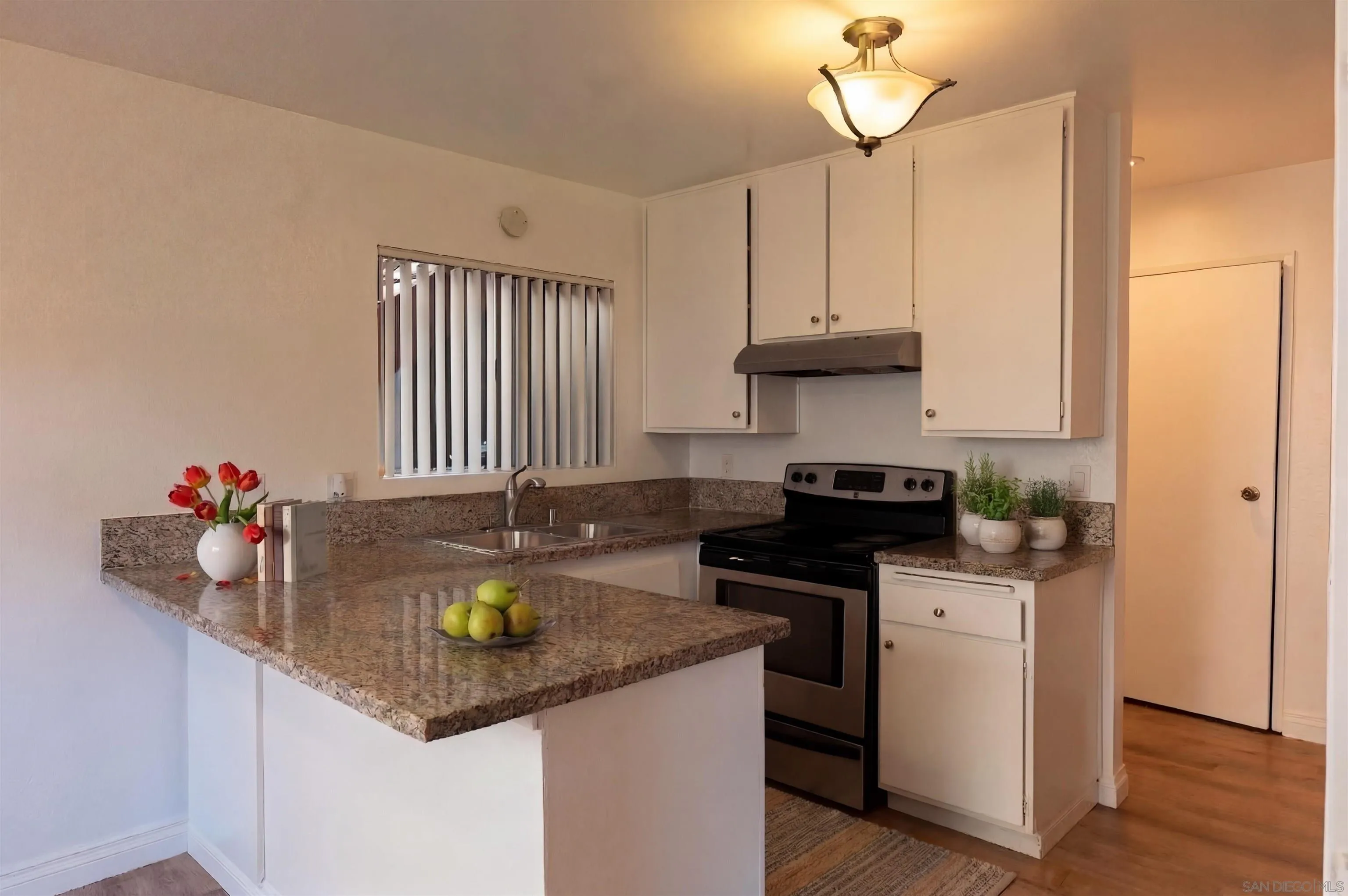 a kitchen with stainless steel appliances granite countertop a sink a stove and cabinets