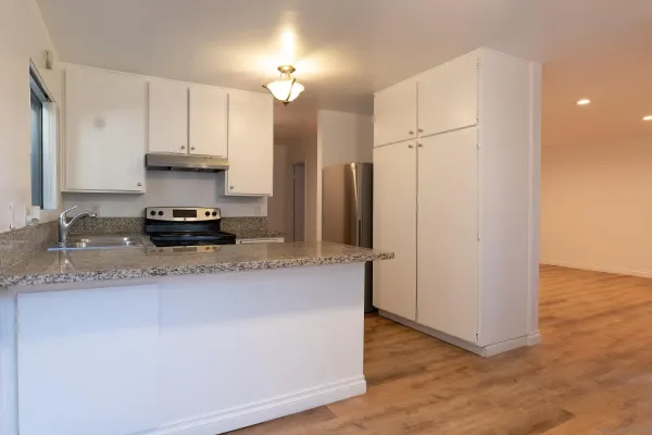 a kitchen with stainless steel appliances a sink a stove a refrigerator and cabinets