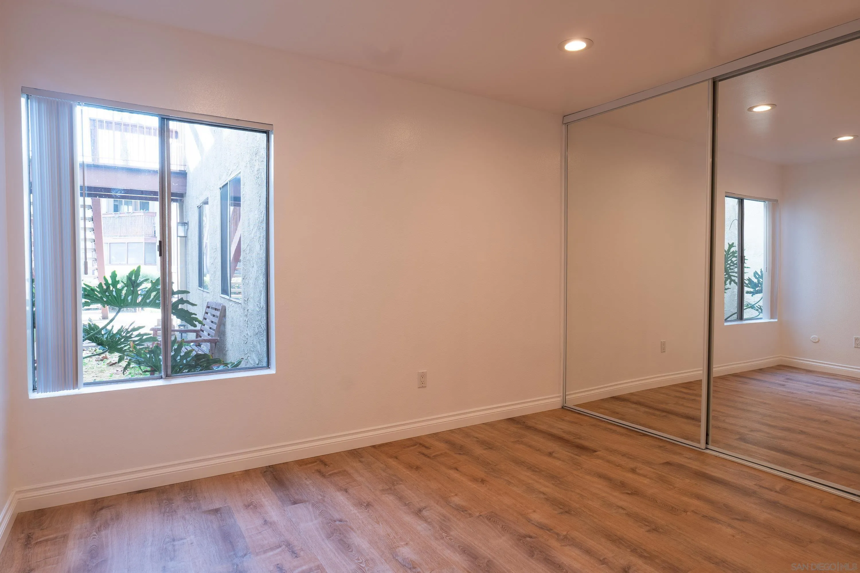 5513 Adobe Falls Road, Unit 2 San Diego, CA 92120 - Photo 21 of 40 an empty room with wooden floor and windows