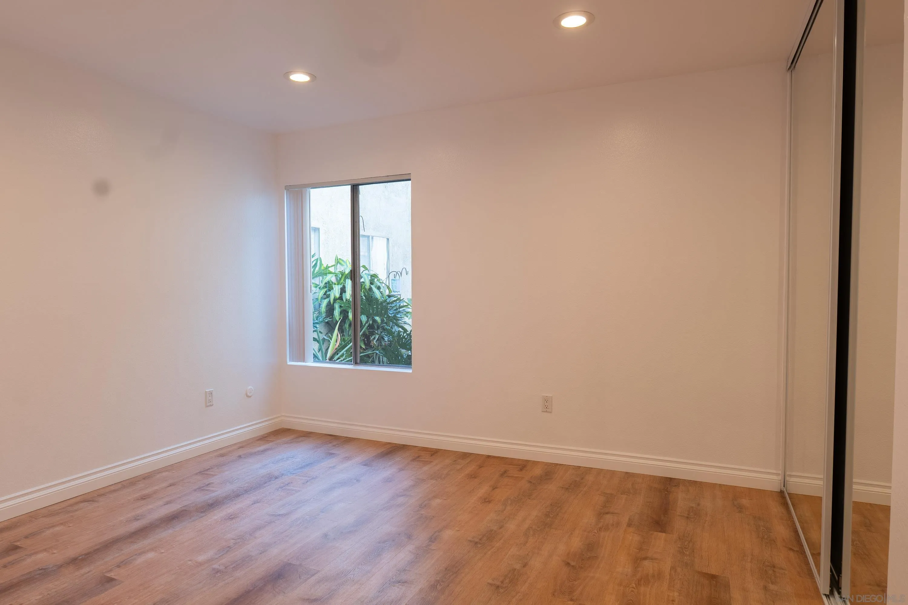 5513 Adobe Falls Road, Unit 2 San Diego, CA 92120 - Photo 22 of 40 an empty room with wooden floor and windows