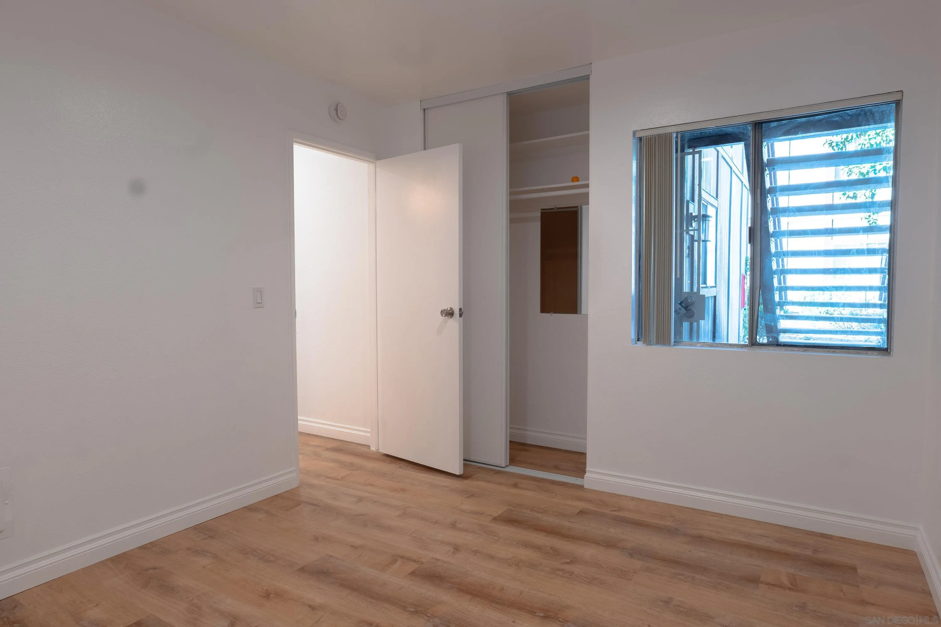 5513 Adobe Falls Road, Unit 2 San Diego, CA 92120 - Photo 28 of 40 a view of an empty room with wooden floor and a window