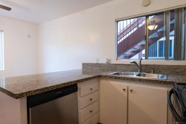 a kitchen with granite countertop a sink and a window