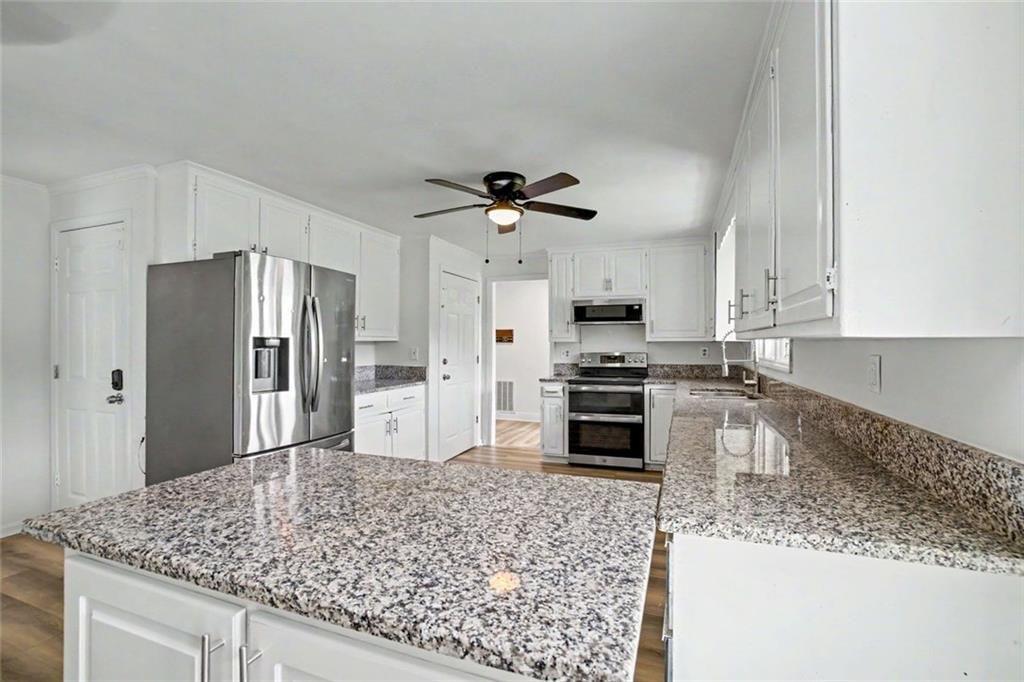 1605 Shackelford Road Griffin, GA 30224 - Photo 14 of 51 a kitchen with stainless steel appliances granite countertop a sink refrigerator and microwave