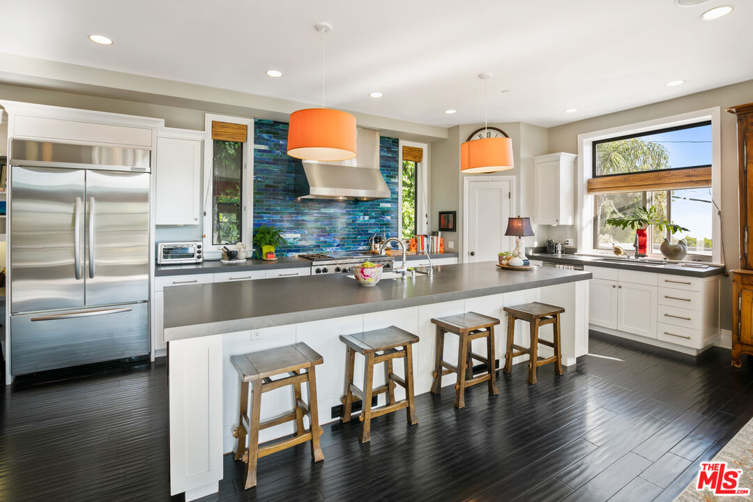 a kitchen with stainless steel appliances a dining table chairs stove and sink