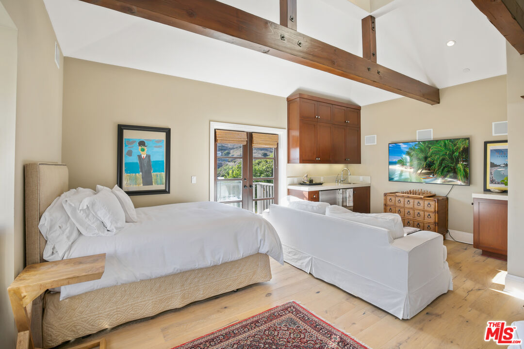 2962 Valmere Drive Malibu, CA 90265 - Photo 18 of 50 a bedroom with a large bed and a flat screen tv